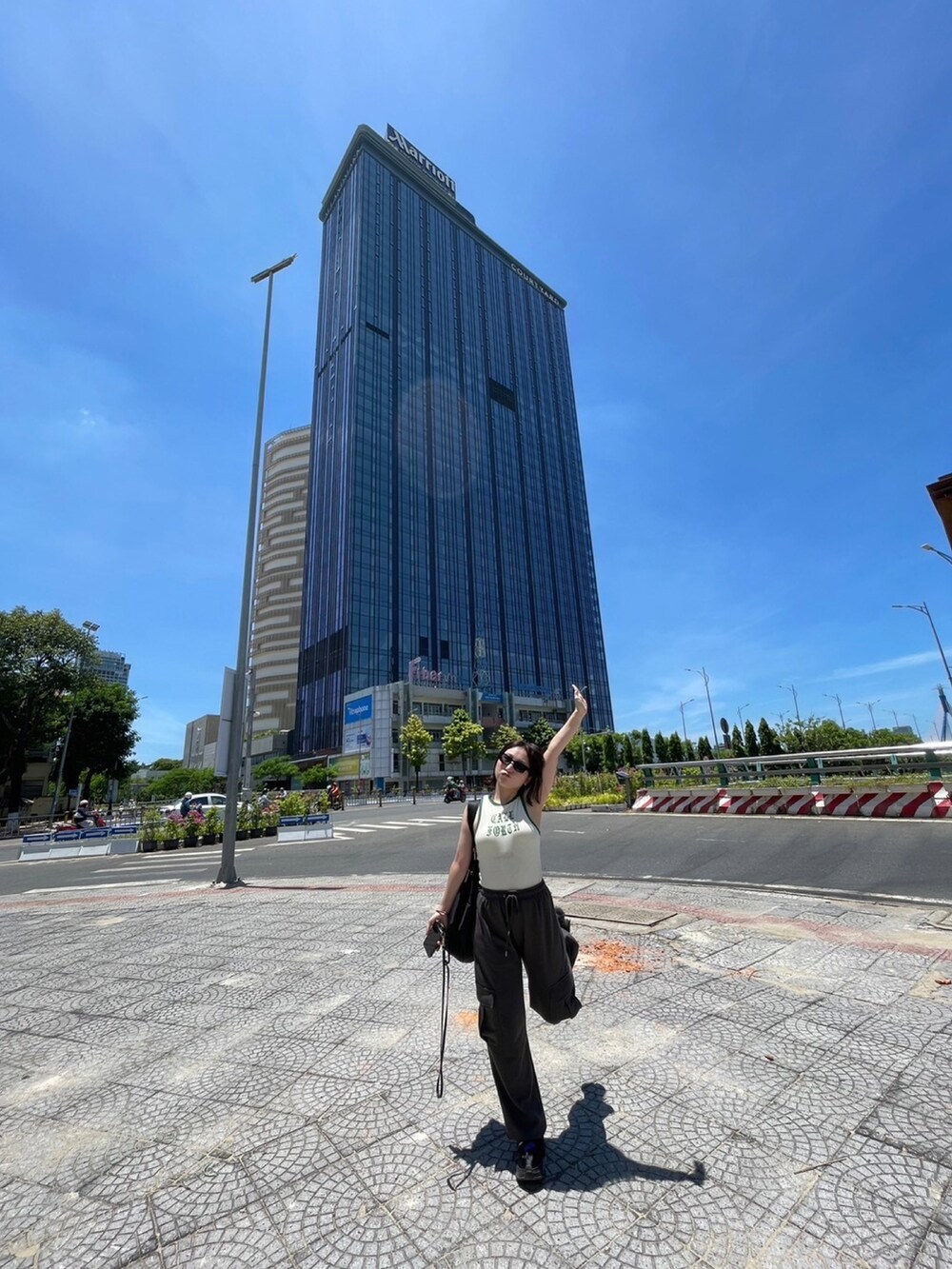 ホワイト系のタンクトップ、グレー系のスウェットパンツ、ブラック系のスニーカーを着用したレディースの夏コーディネートの2枚目の写真