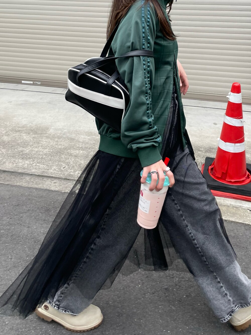 グリーン系のジャケット/アウター、ブラック系のスウェット、ブラック系のデニムパンツを着用したレディースの春コーディネートの2枚目の写真