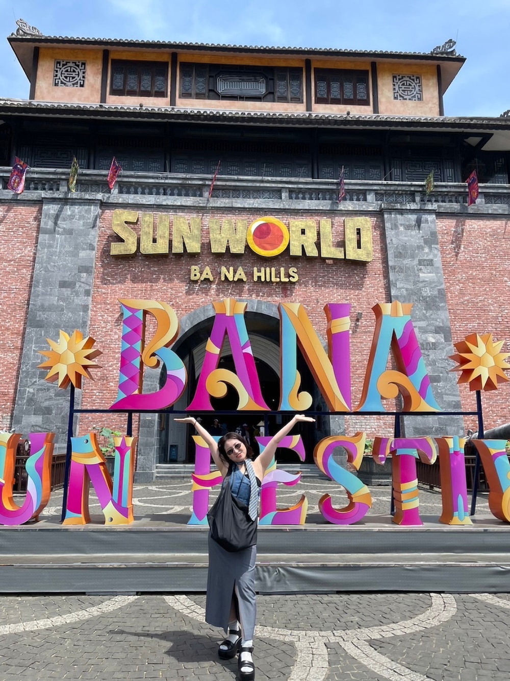 ブルー系のトップス、グレー系のスカート、ブラック系のサンダルを着用したレディースの夏コーディネートの2枚目の写真