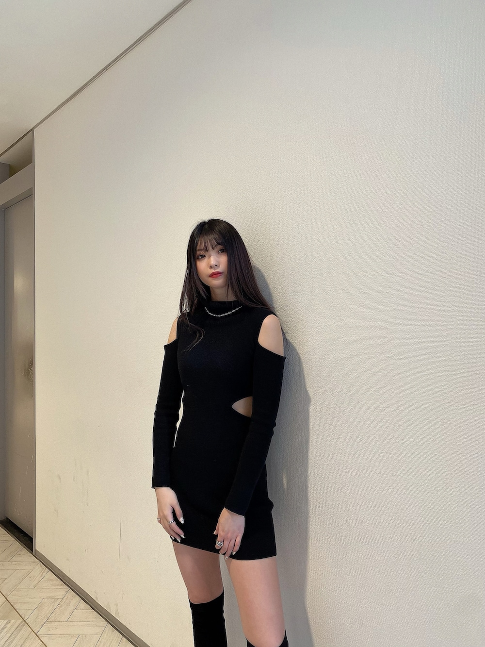 ブラック系のワンピース、ブラック系のブーツ、シルバー系のアクセサリーを着用したレディースの冬コーディネートの4枚目の写真