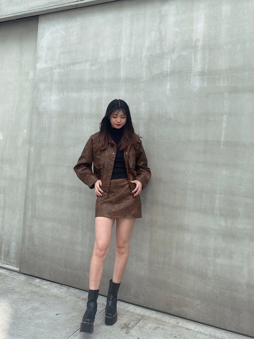 ブラウン系のベスト、ブラック系のTシャツ/カットソー、ブラウン系のスカートを着用したレディースの秋コーディネートの2枚目の写真