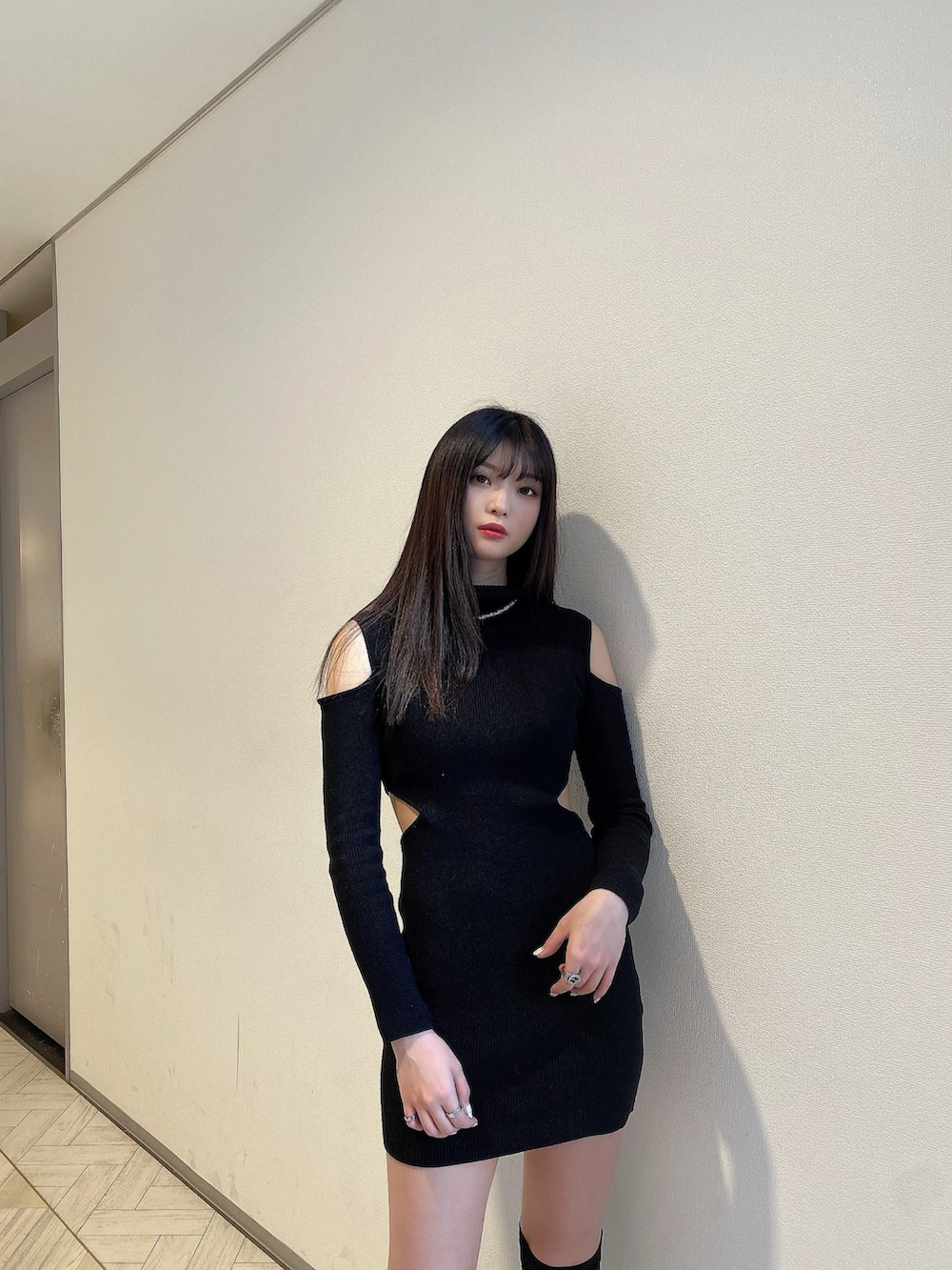 ブラック系のワンピース、ブラック系のブーツ、シルバー系のアクセサリーを着用したレディースの冬コーディネートの3枚目の写真