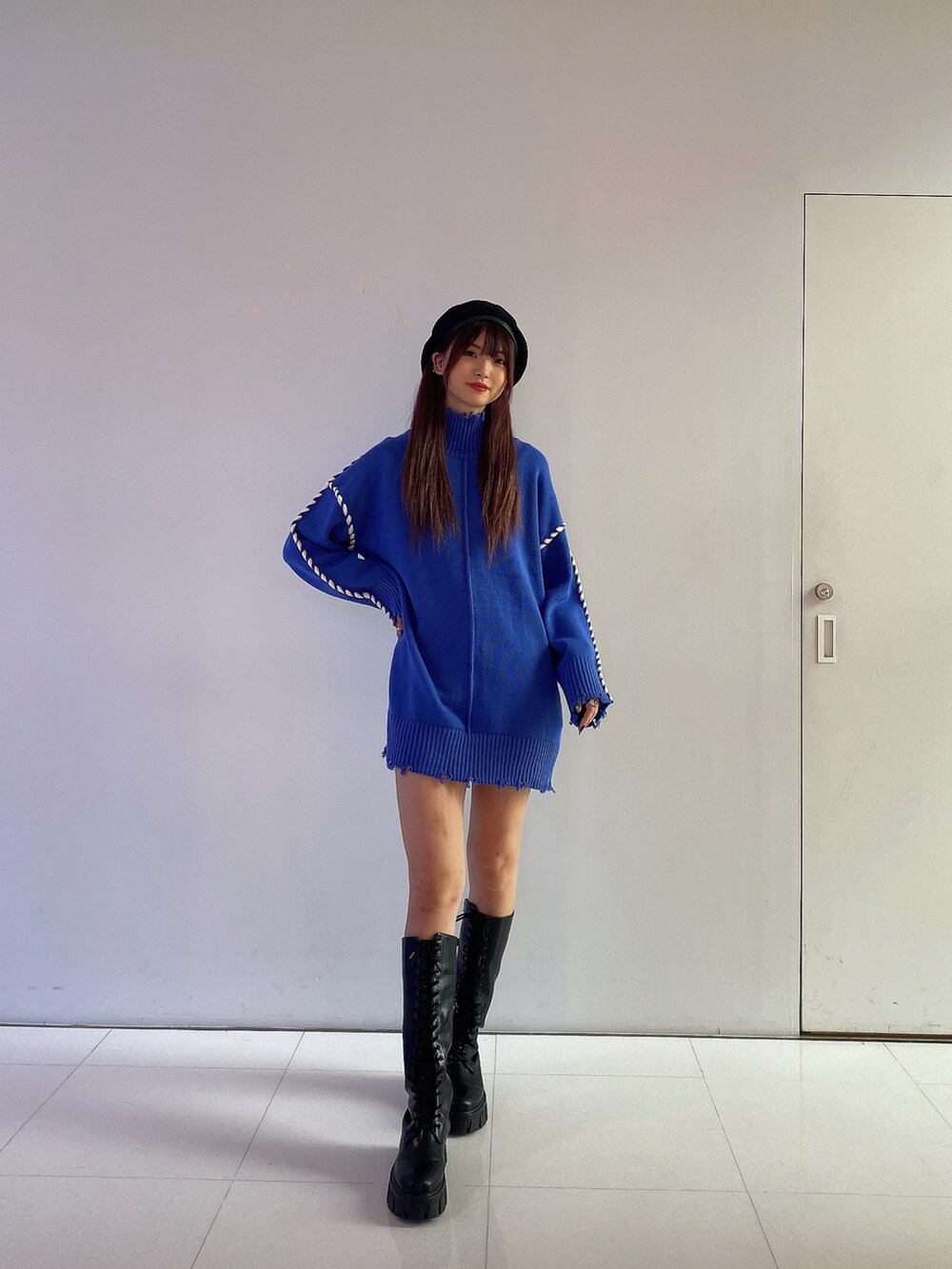 ブルー系のワンピース、ブラック系のブーツ、ブラック系のハンチング/ベレー帽を着用したレディースの秋コーディネートの2枚目の写真