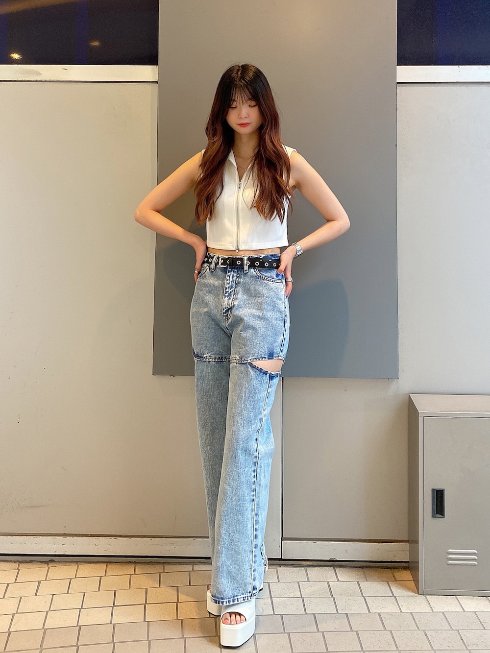 ブルー系のデニムパンツ、ブラック系のサンダル、ホワイト系のTシャツ/カットソーを着用したレディースの夏コーディネートの2枚目の写真