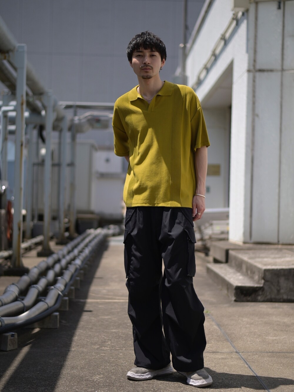 イエロー系のポロシャツ、グレー系のカーゴパンツを着用したメンズの春コーディネートの5枚目の写真