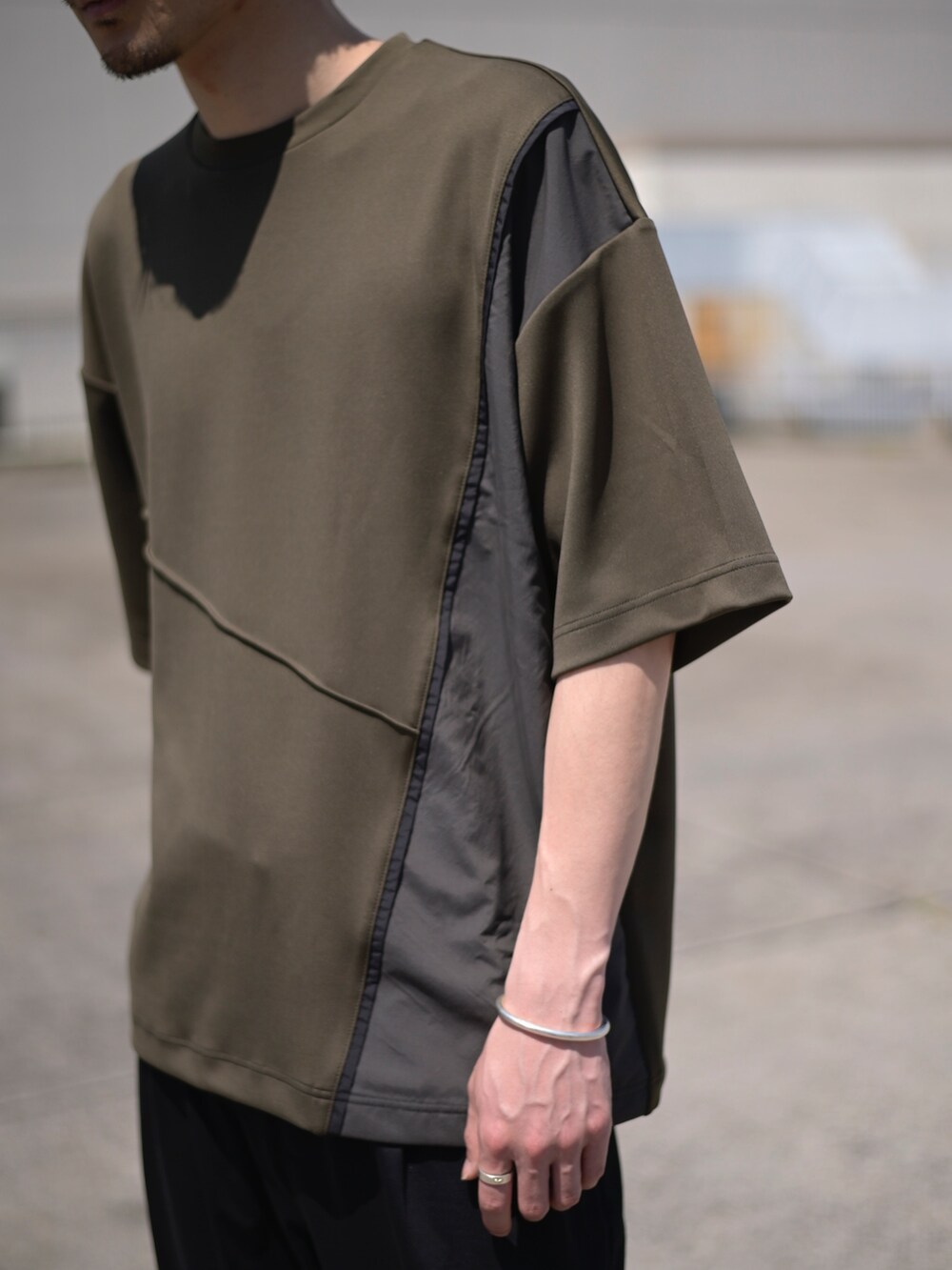 グレー系のTシャツ/カットソー、ブラック系のスラックスを着用したメンズの春コーディネートの5枚目の写真