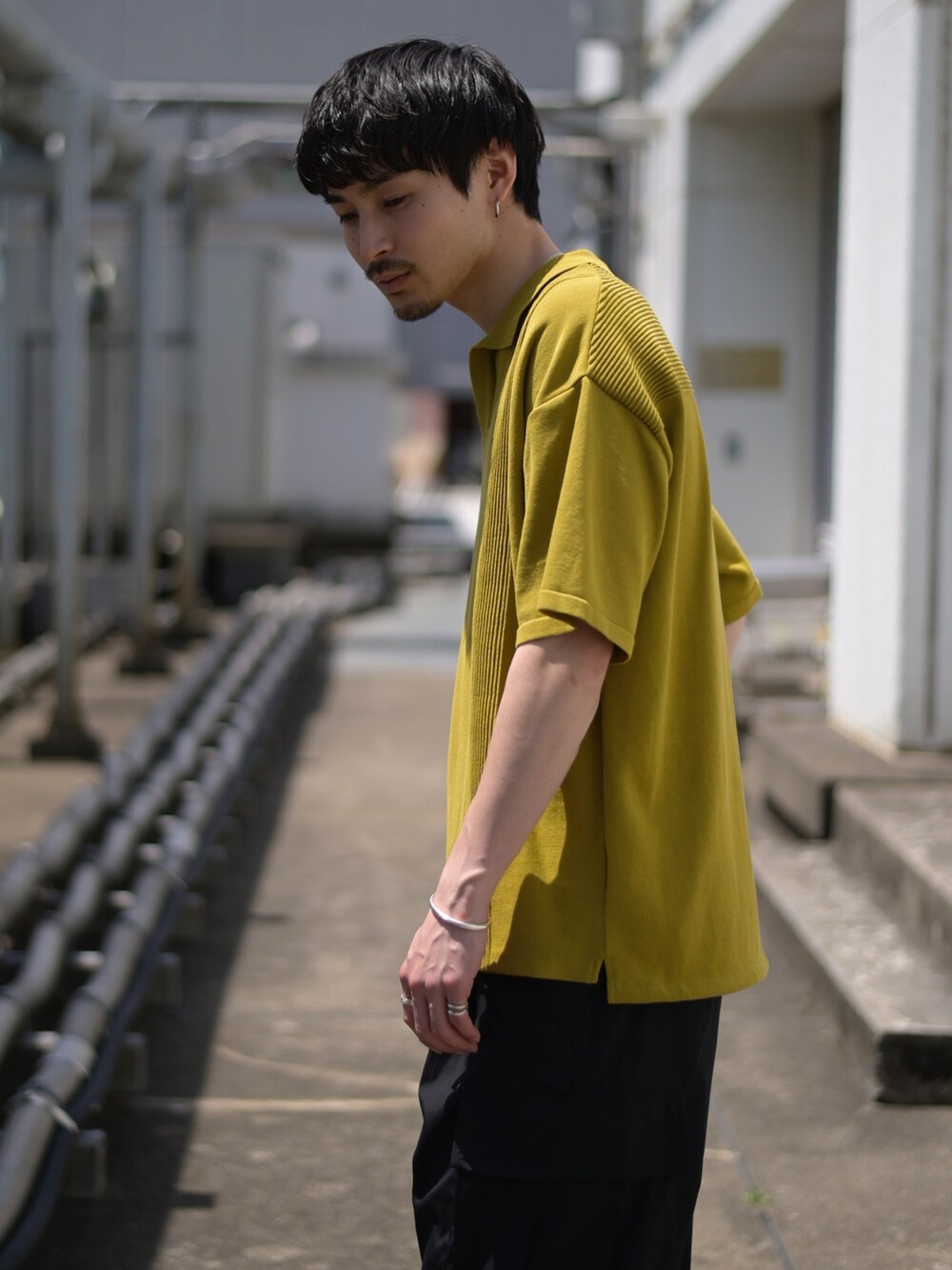 イエロー系のポロシャツ、グレー系のカーゴパンツを着用したメンズの春コーディネートの2枚目の写真