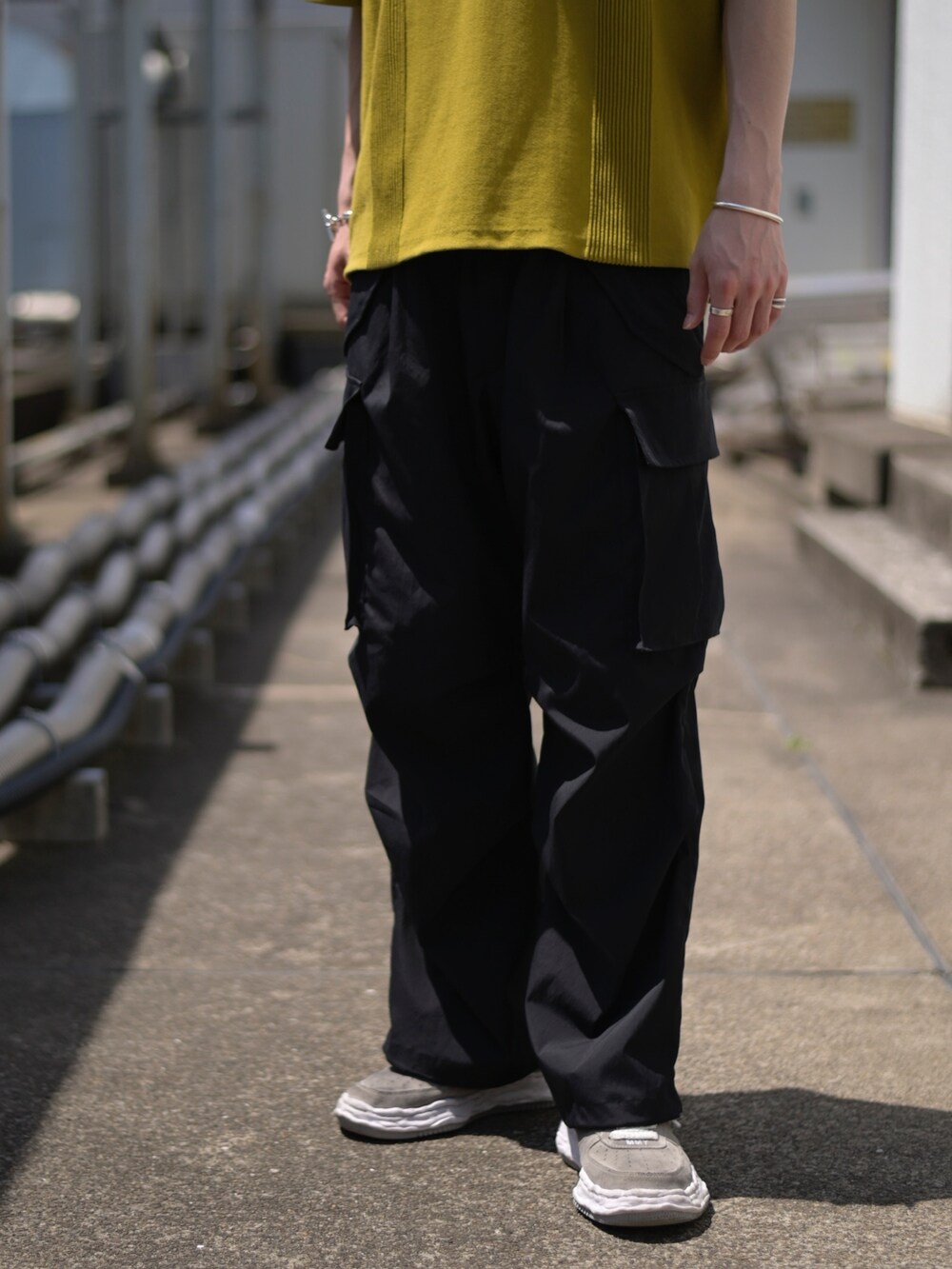 イエロー系のポロシャツ、グレー系のカーゴパンツを着用したメンズの春コーディネートの4枚目の写真