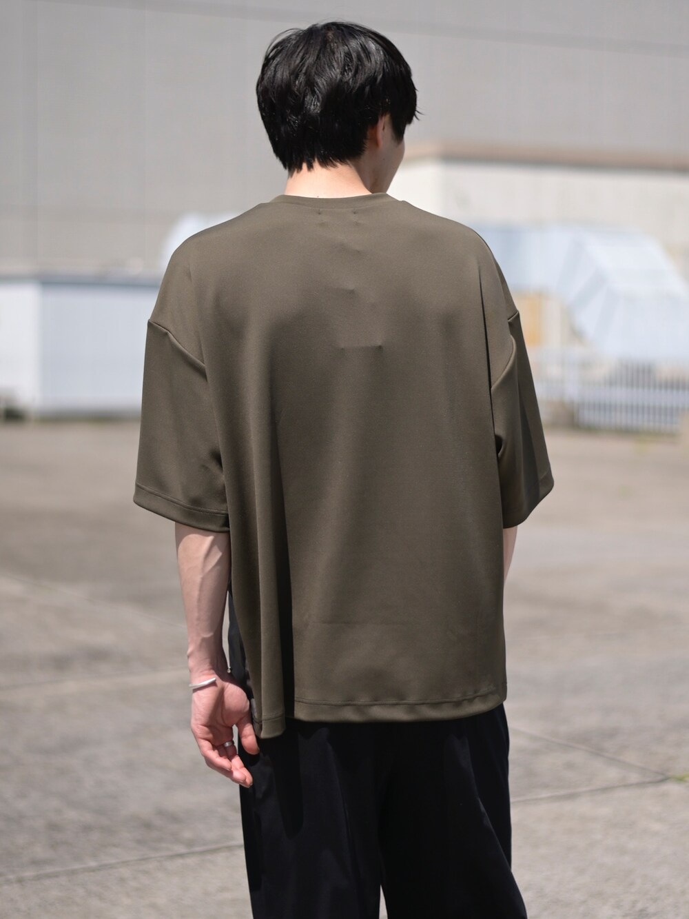 グレー系のTシャツ/カットソー、ブラック系のスラックスを着用したメンズの春コーディネートの4枚目の写真