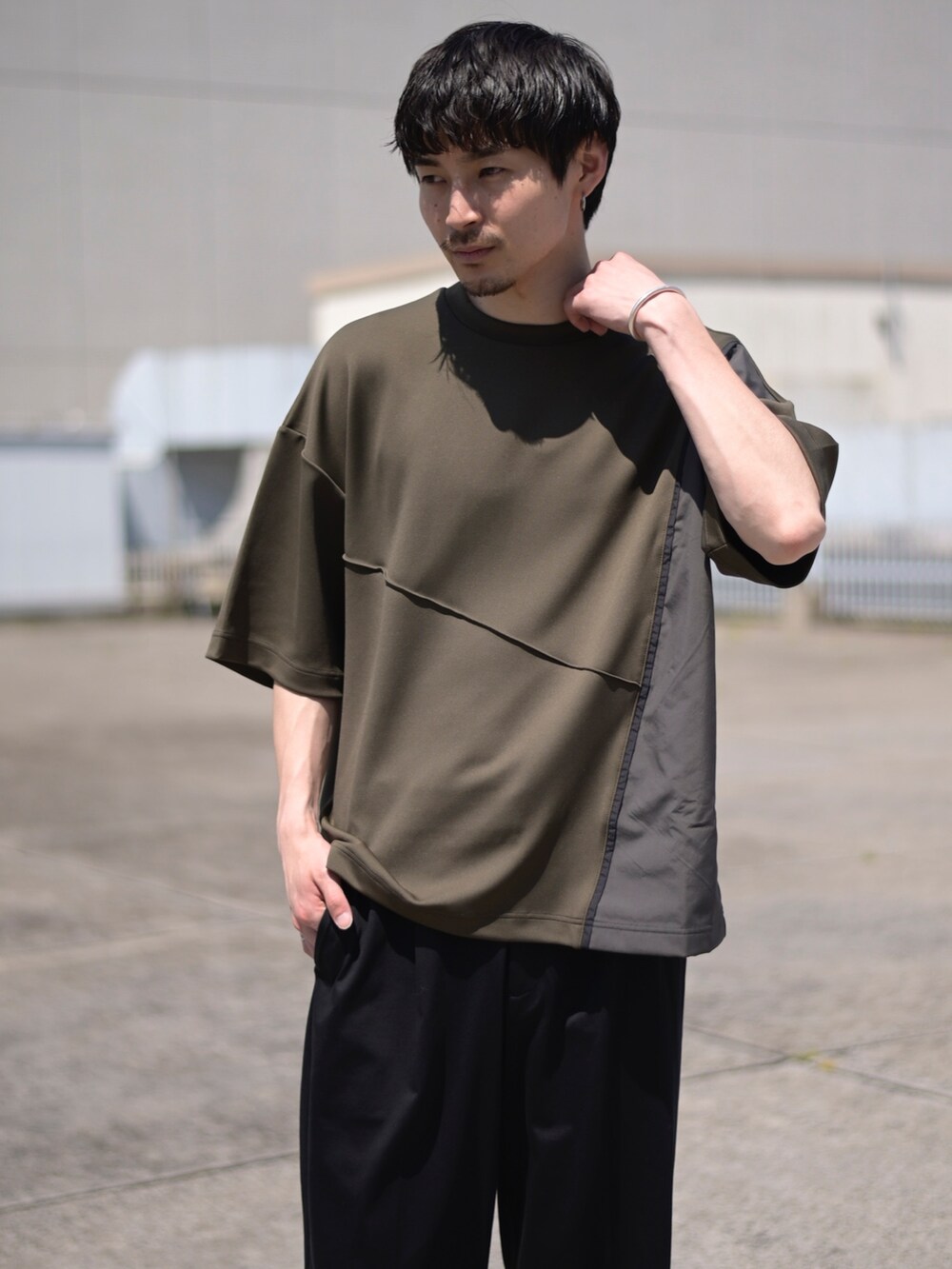 グレー系のTシャツ/カットソー、ブラック系のスラックスを着用したメンズの春コーディネートの2枚目の写真