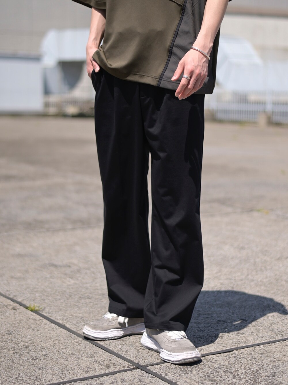 グレー系のTシャツ/カットソー、ブラック系のスラックスを着用したメンズの春コーディネートの3枚目の写真