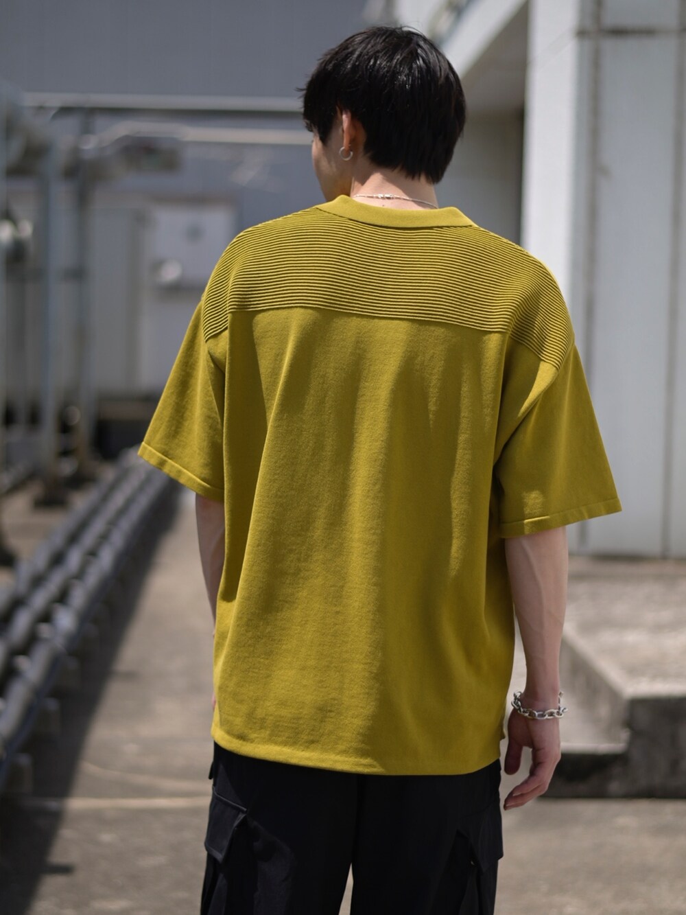 イエロー系のポロシャツ、グレー系のカーゴパンツを着用したメンズの春コーディネートの3枚目の写真