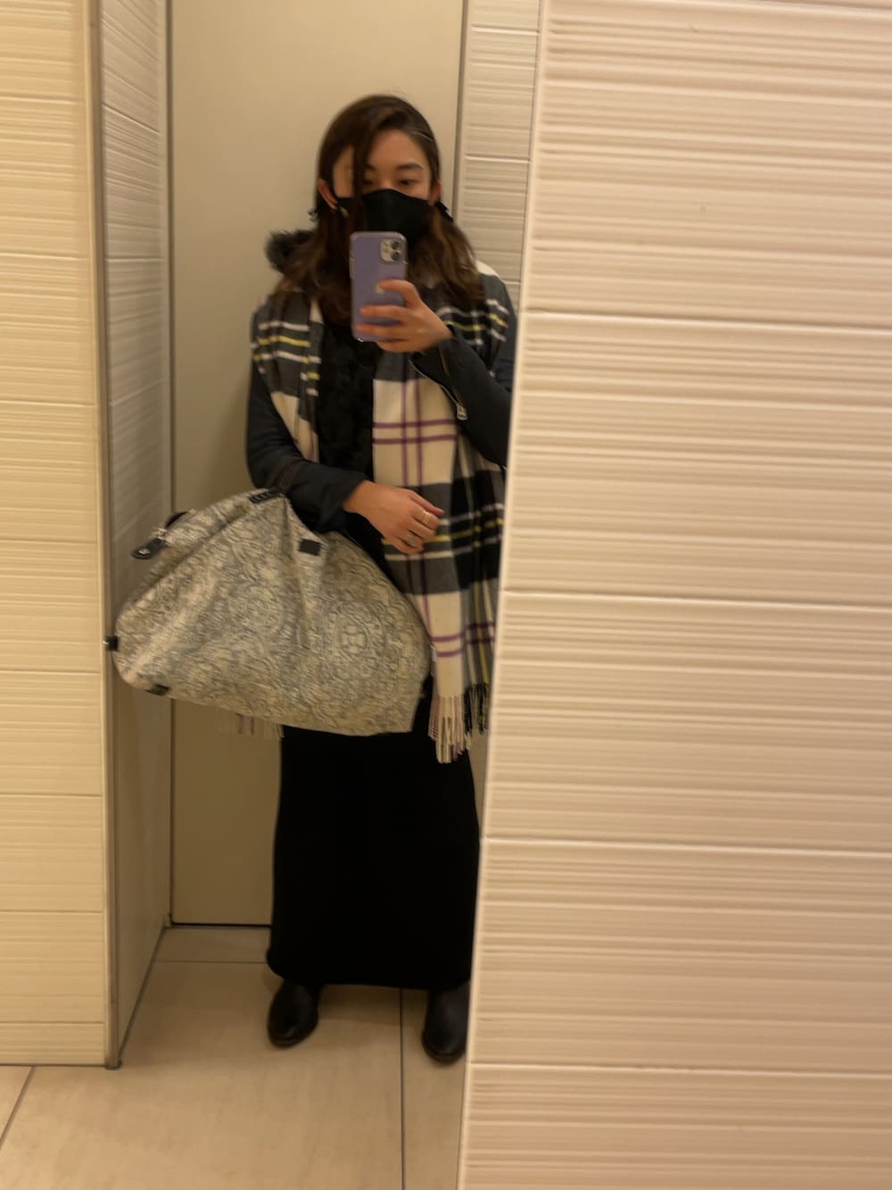 グレー系のムートンコート、ブルー系のライダースジャケット、ブラック系のスカートを着用したレディースの秋コーディネートの2枚目の写真