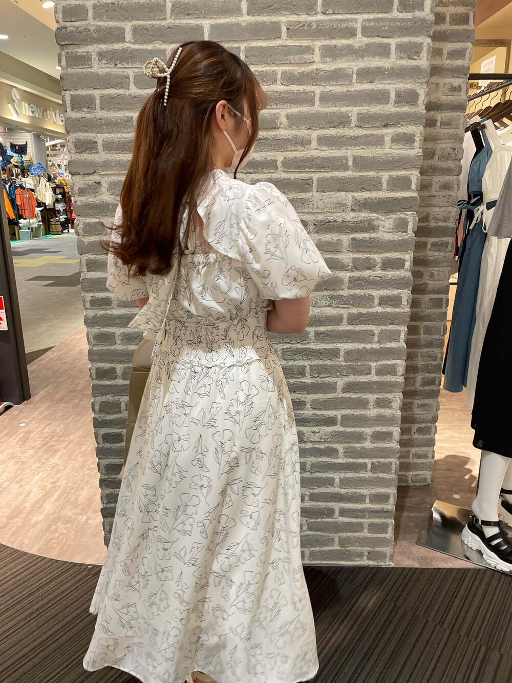 ホワイト系のワンピース、ブラウン系のトートバッグ、ピンク系のその他小物を着用したレディースの春コーディネートの2枚目の写真