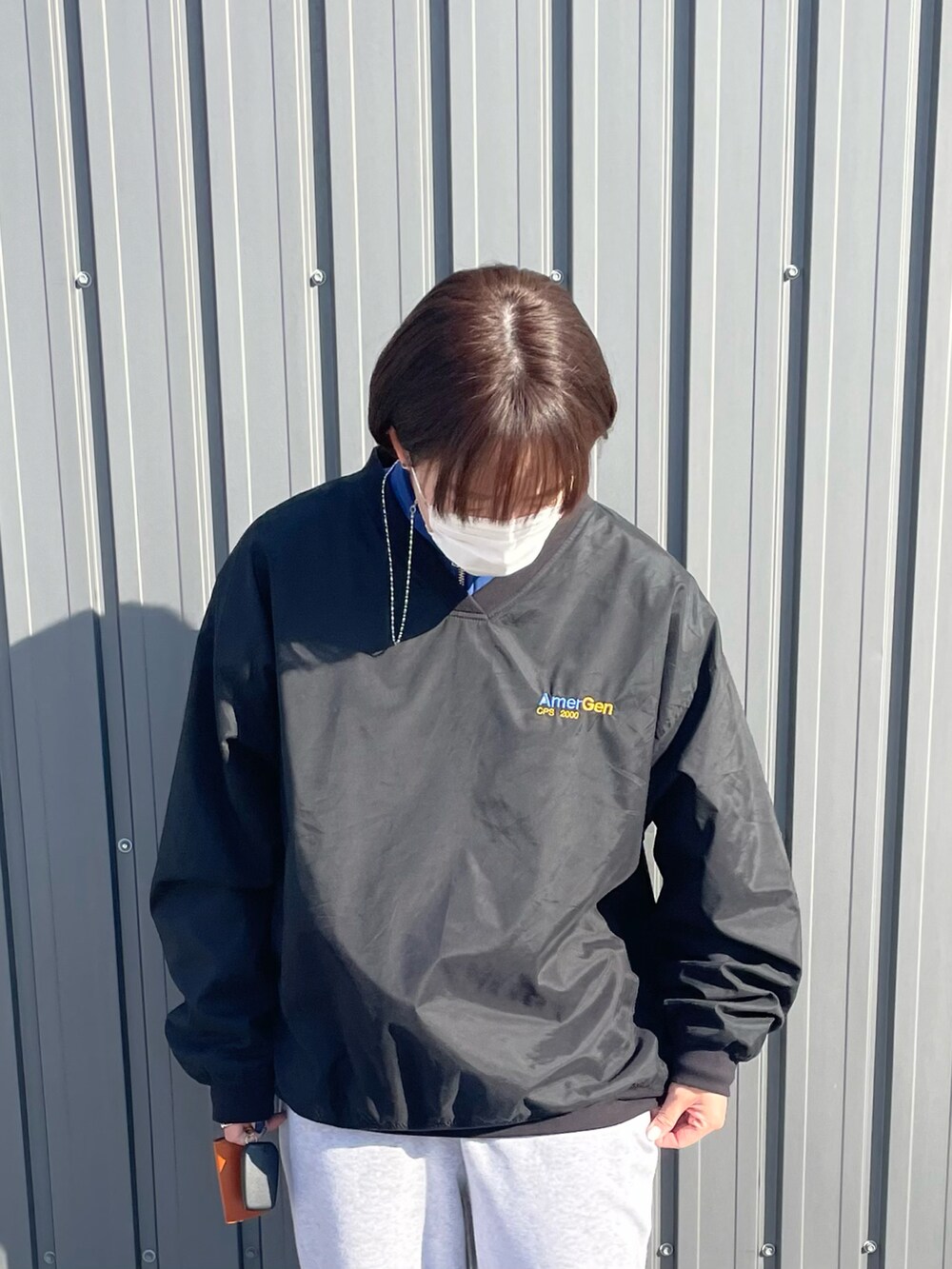 ホワイト系のスニーカー、グレー系のスウェットパンツ、ブラック系のトップスを着用したレディースの冬コーディネートの2枚目の写真