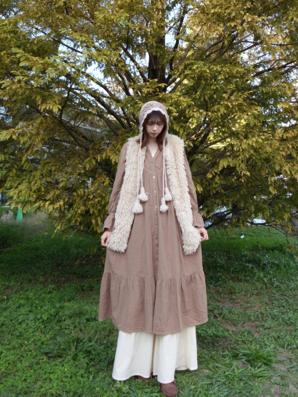 ブラウン系のワンピース、ベージュ系のベストを着用したレディースの冬コーディネートの2枚目の写真