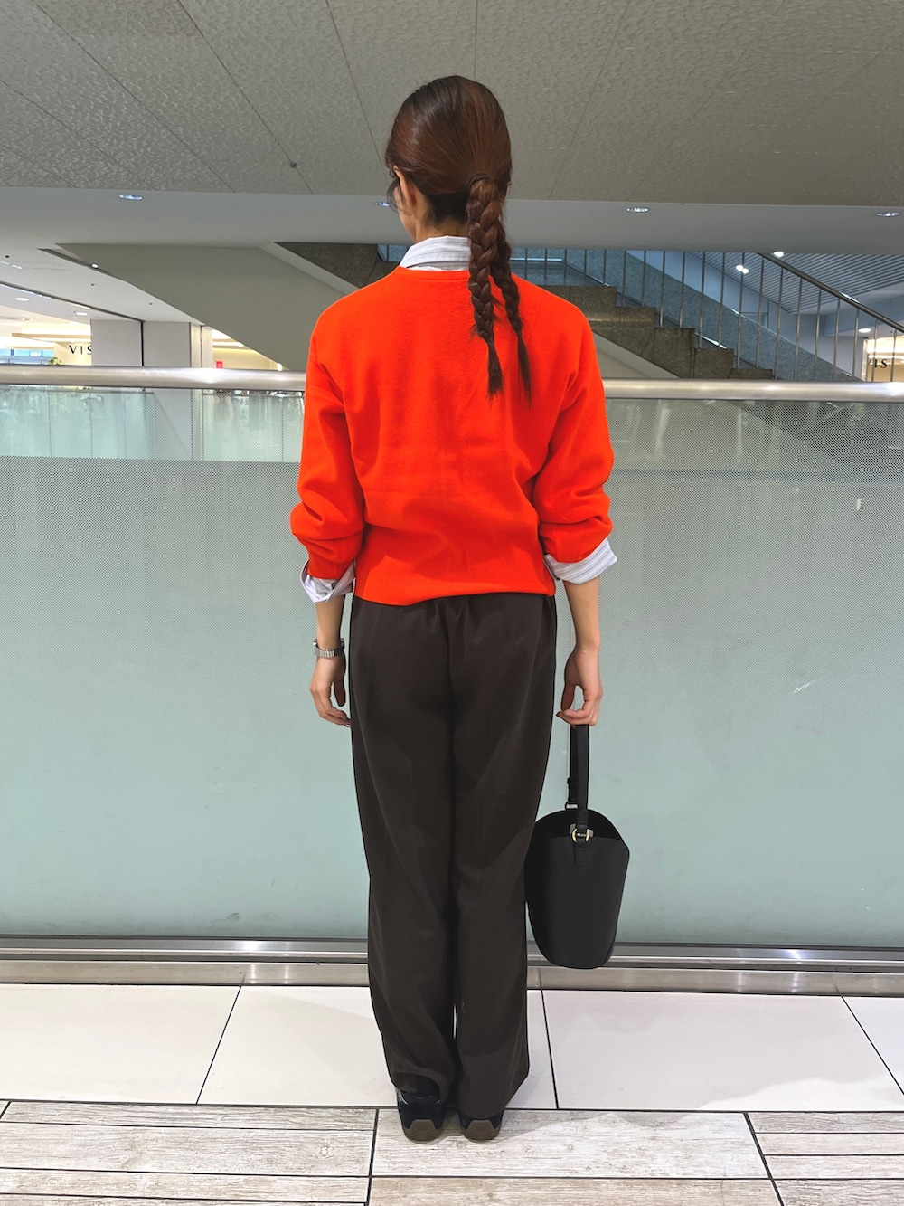 レッド系のカーディガン/ボレロ、ブラウン系のその他パンツ、ブラック系のハンドバッグを着用したレディースの秋コーディネートの3枚目の写真