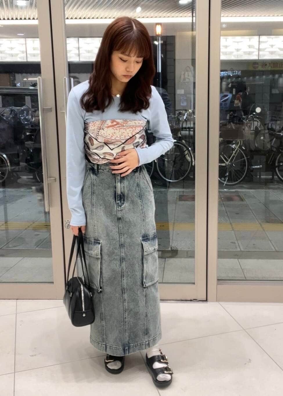 ブラック系のボストンバッグ、ブルー系のTシャツ/カットソー、ブラック系のサンダルを着用したレディースの春コーディネートの2枚目の写真