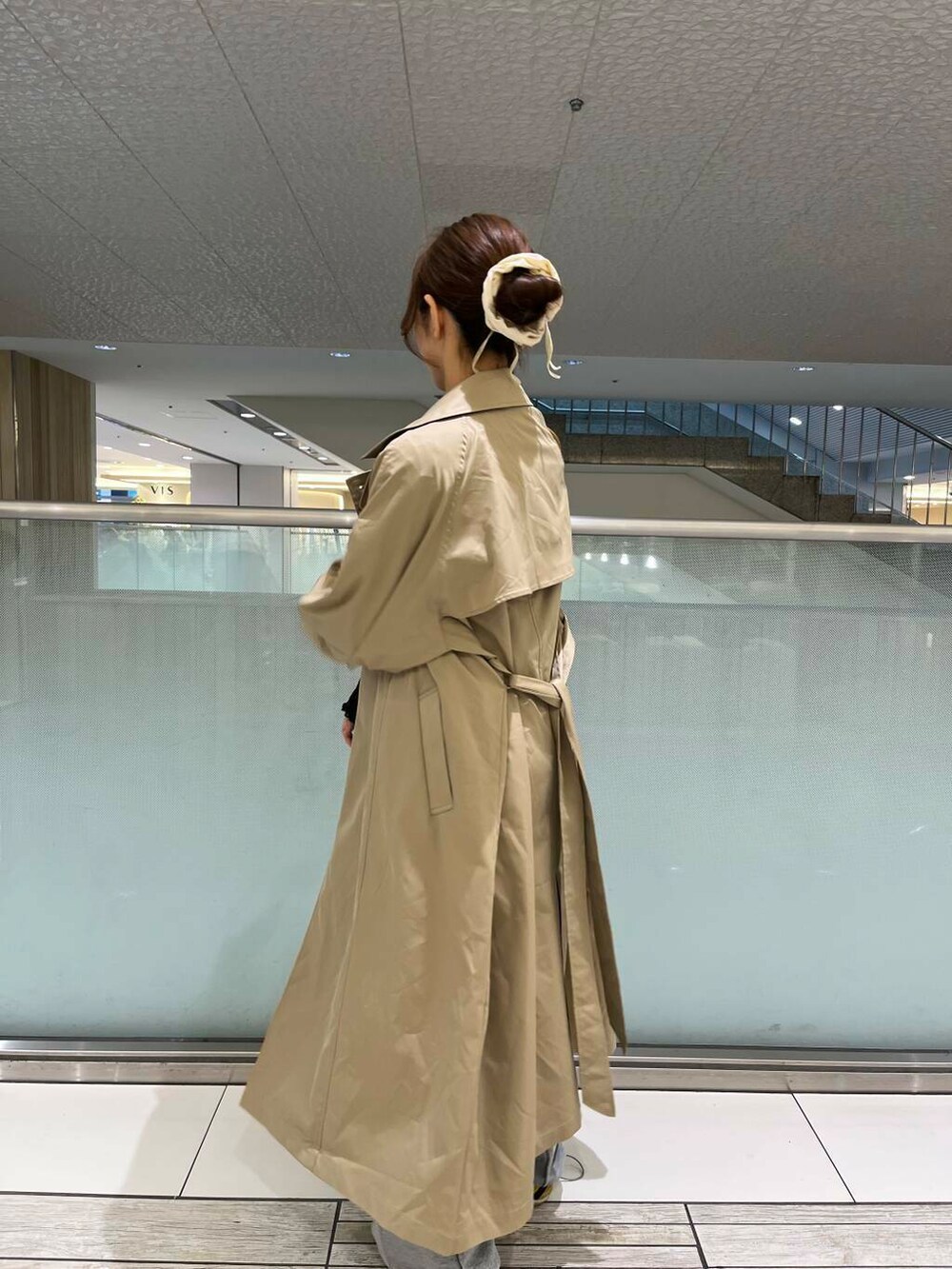 ブラック系のトートバッグ、ベージュ系のトレンチコート、ブラック系のTシャツ/カットソーを着用したレディースの春コーディネートの3枚目の写真
