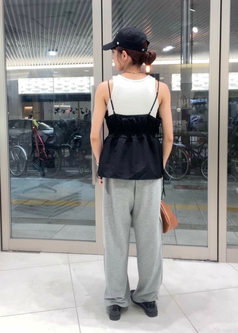 イエロー系のハンドバッグ、ブラック系のキャミソール、グレー系のその他パンツを着用したレディースの夏コーディネートの2枚目の写真