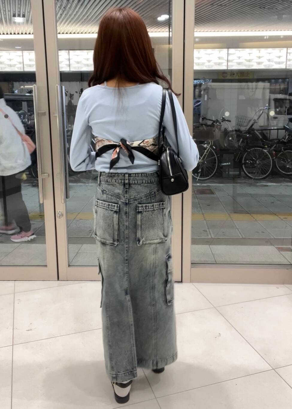 ブラック系のボストンバッグ、ブルー系のTシャツ/カットソー、ブラック系のサンダルを着用したレディースの春コーディネートの3枚目の写真