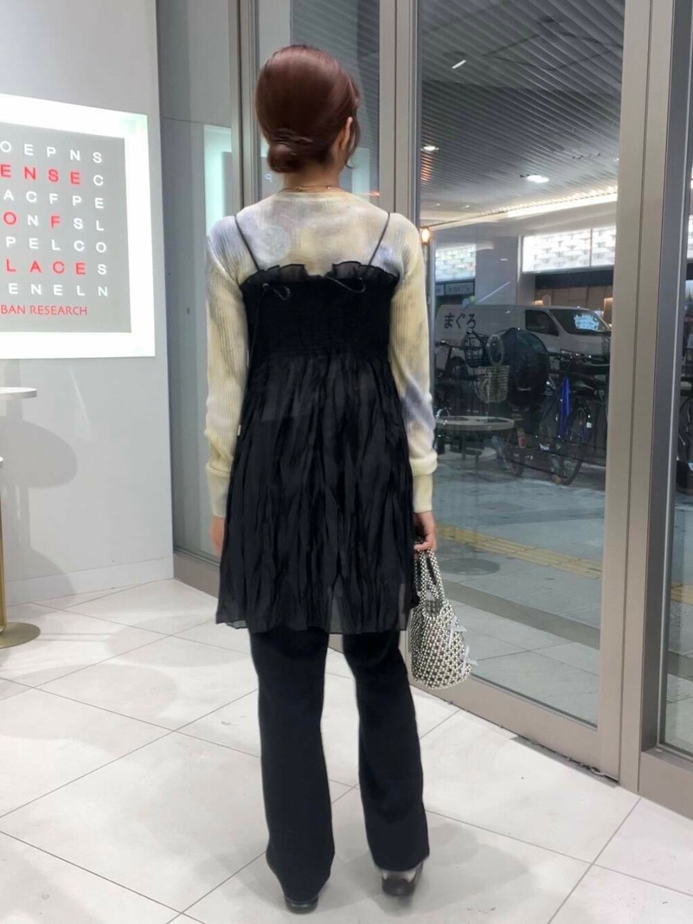 ブラック系のその他パンツ、グレー系のハンドバッグ、ホワイト系のスニーカーを着用したレディースの夏コーディネートの2枚目の写真