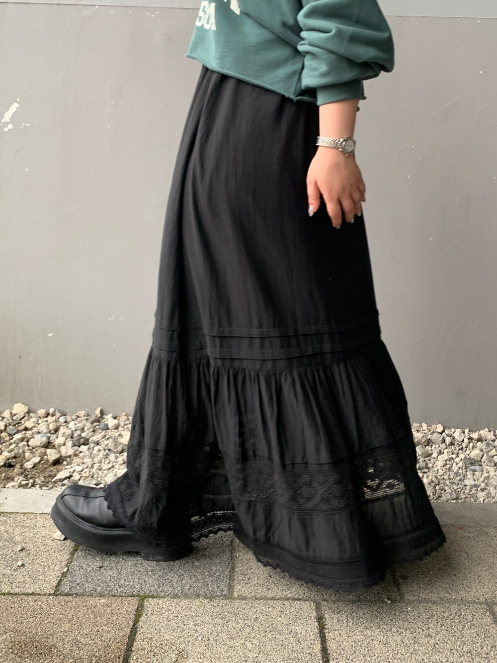グリーン系のパーカー、ブラック系のスカートを着用したレディースの夏コーディネートの6枚目の写真