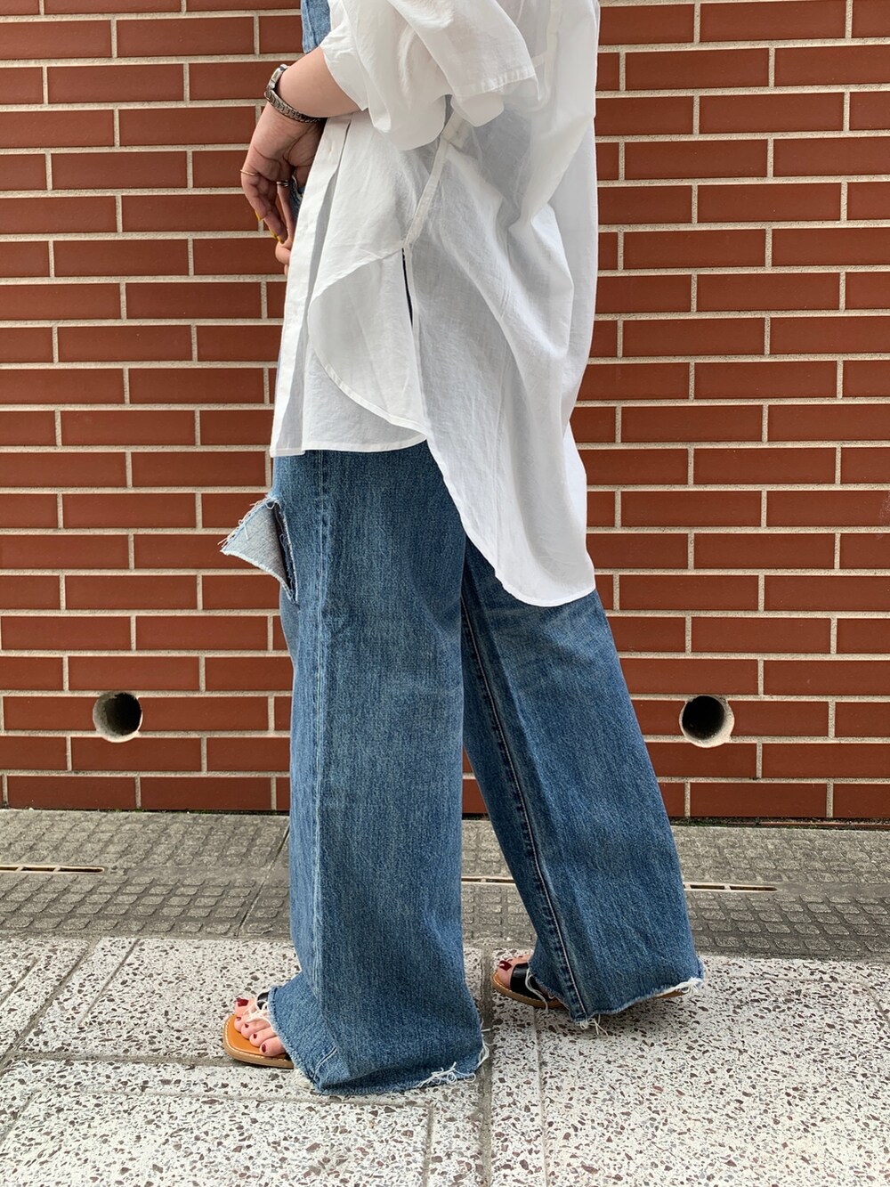 ブルー系のキャミソール、ホワイト系のシャツ/ブラウス、ブルー系のデニムパンツを着用したレディースの春コーディネートの7枚目の写真