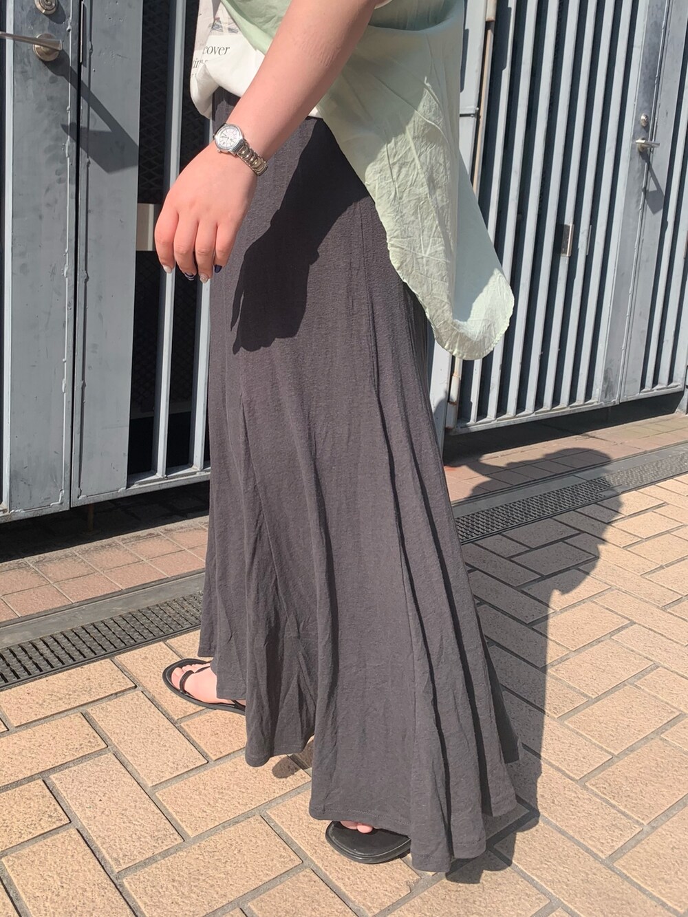 ホワイト系のTシャツ/カットソー、グリーン系のシャツ/ブラウス、グレー系のスカートを着用したレディースの春コーディネートの4枚目の写真