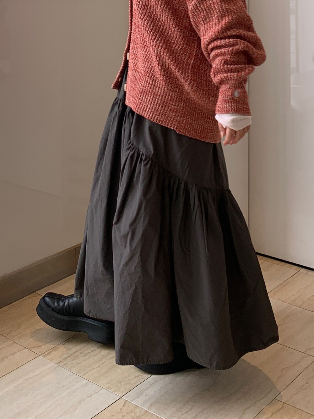 ピンク系のTシャツ/カットソー、オレンジ系のカーディガン/ボレロ、グレー系のスカートを着用したレディースの冬コーディネートの6枚目の写真