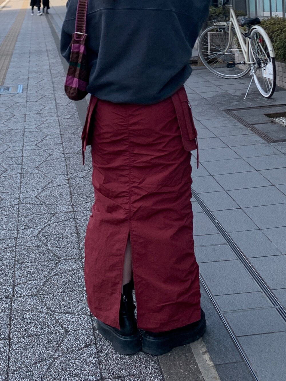 グレー系のスウェット、レッド系のスカート、ブラウン系のハンドバッグを着用したレディースの冬コーディネートの7枚目の写真