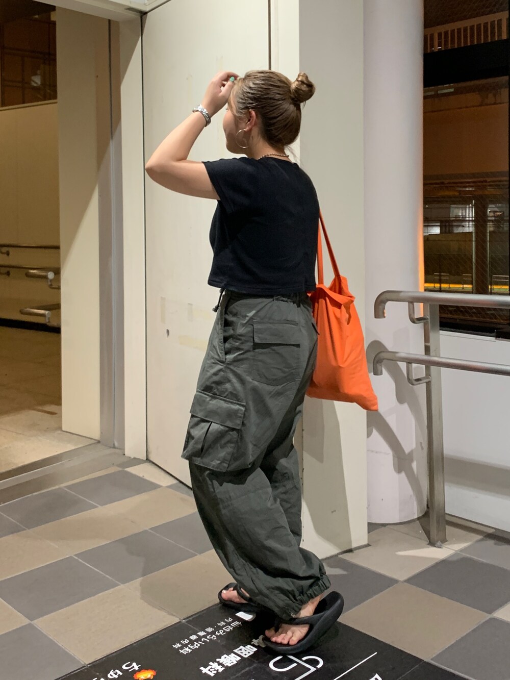 グリーン系のカーゴパンツ、ブラック系のTシャツ/カットソーを着用したレディースの夏コーディネートの2枚目の写真