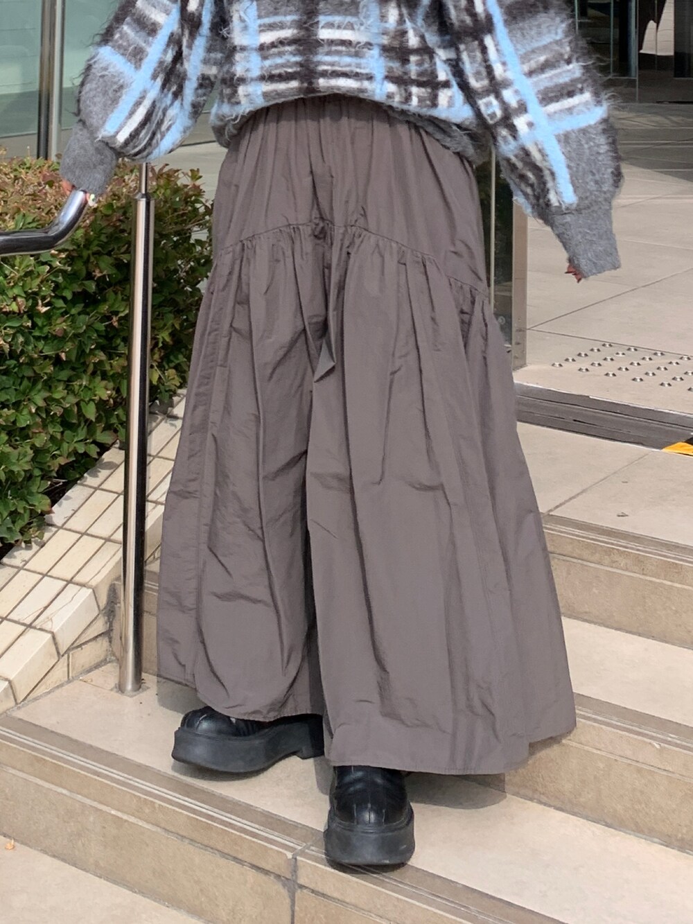 グレー系のニット/セーター、グレー系のスカートを着用したレディースの秋コーディネートの5枚目の写真