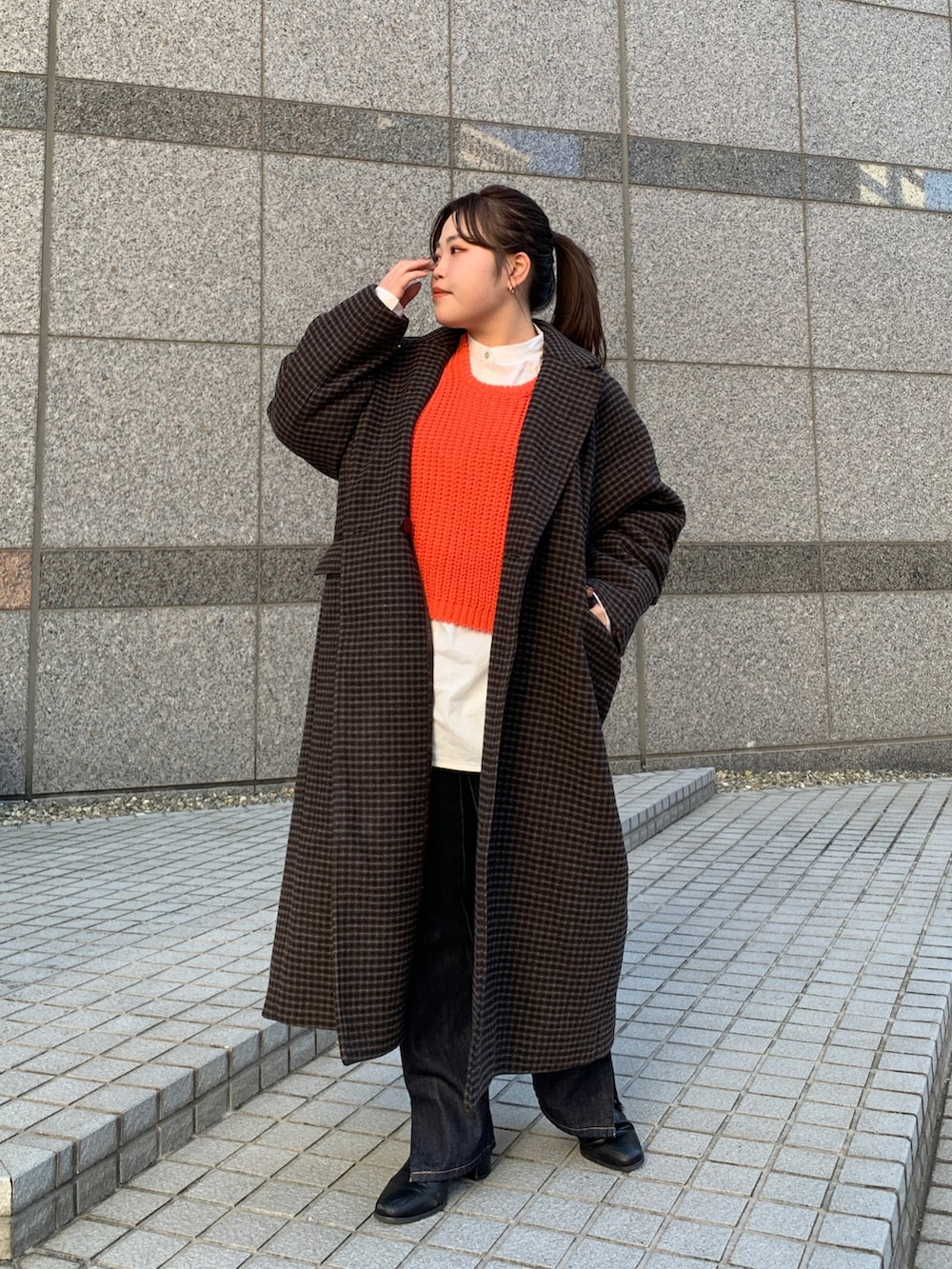 オレンジ系のニット/セーター、その他のチェスターコート、ブルー系のデニムパンツを着用したレディースの秋コーディネートの4枚目の写真