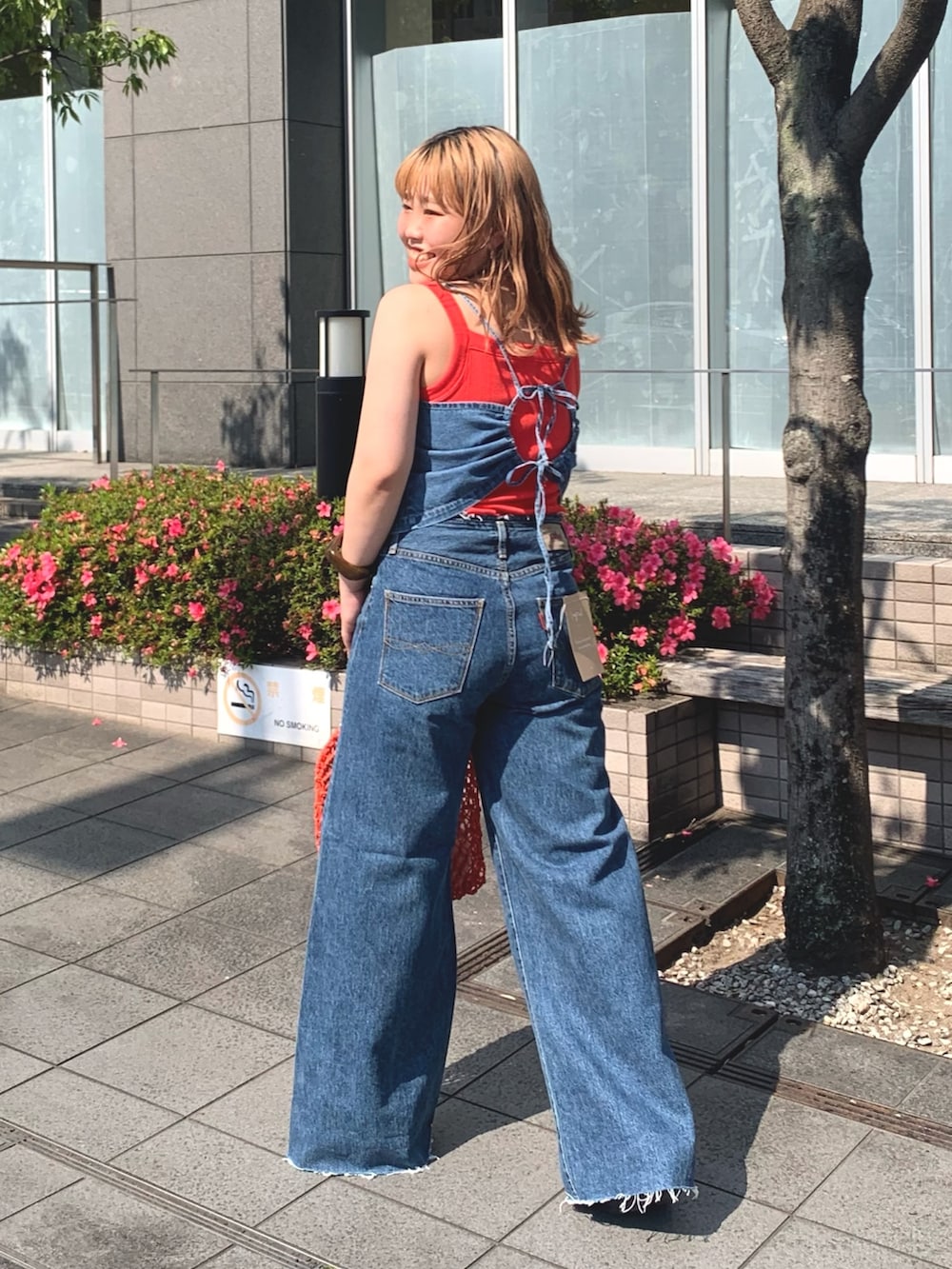 オレンジ系のタンクトップ、オレンジ系のハンドバッグを着用したレディースの夏コーディネートの2枚目の写真