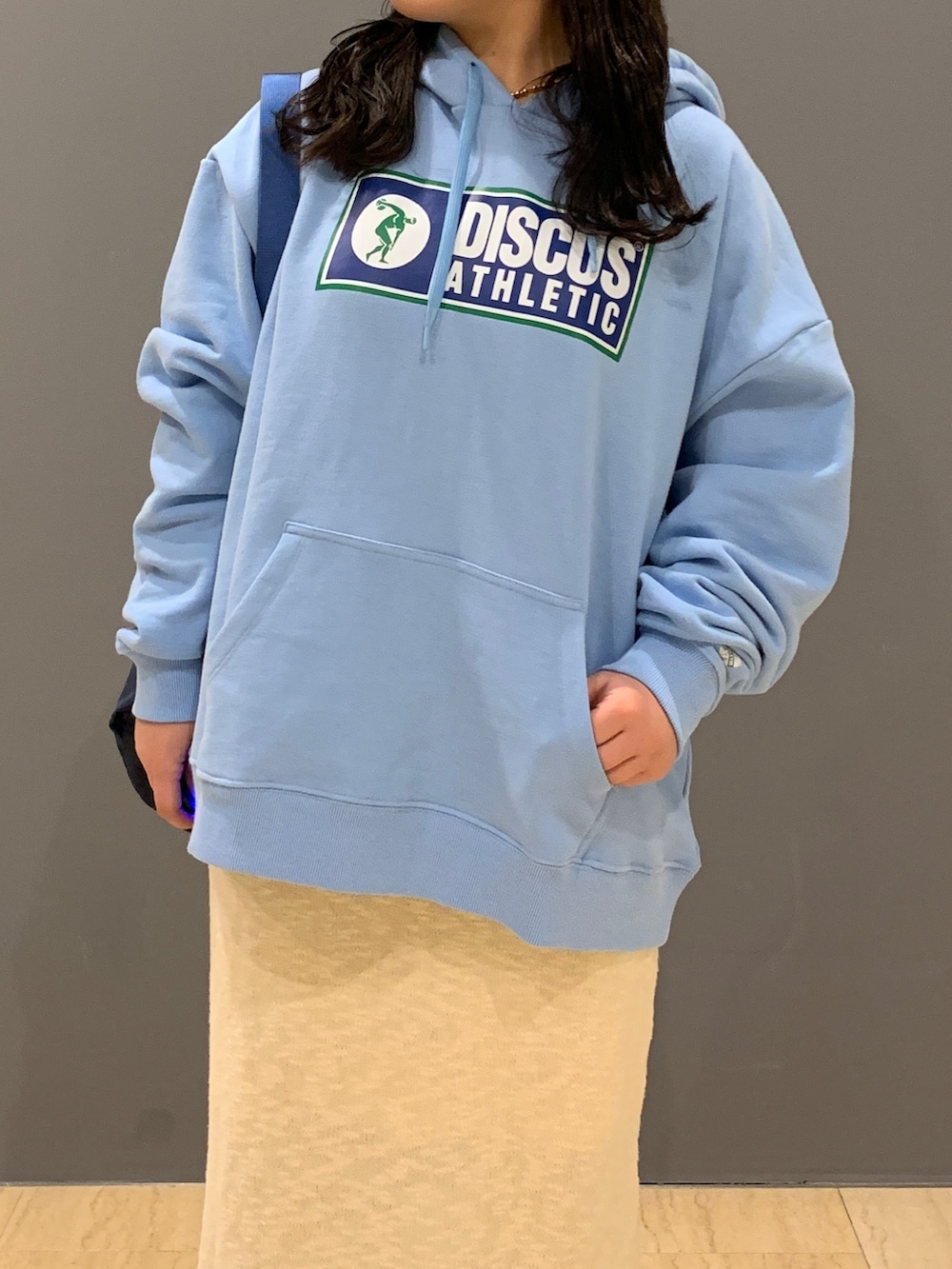 ブルー系のパーカー、ホワイト系のスカート、ブルー系のトートバッグを着用したレディースの冬コーディネートの4枚目の写真