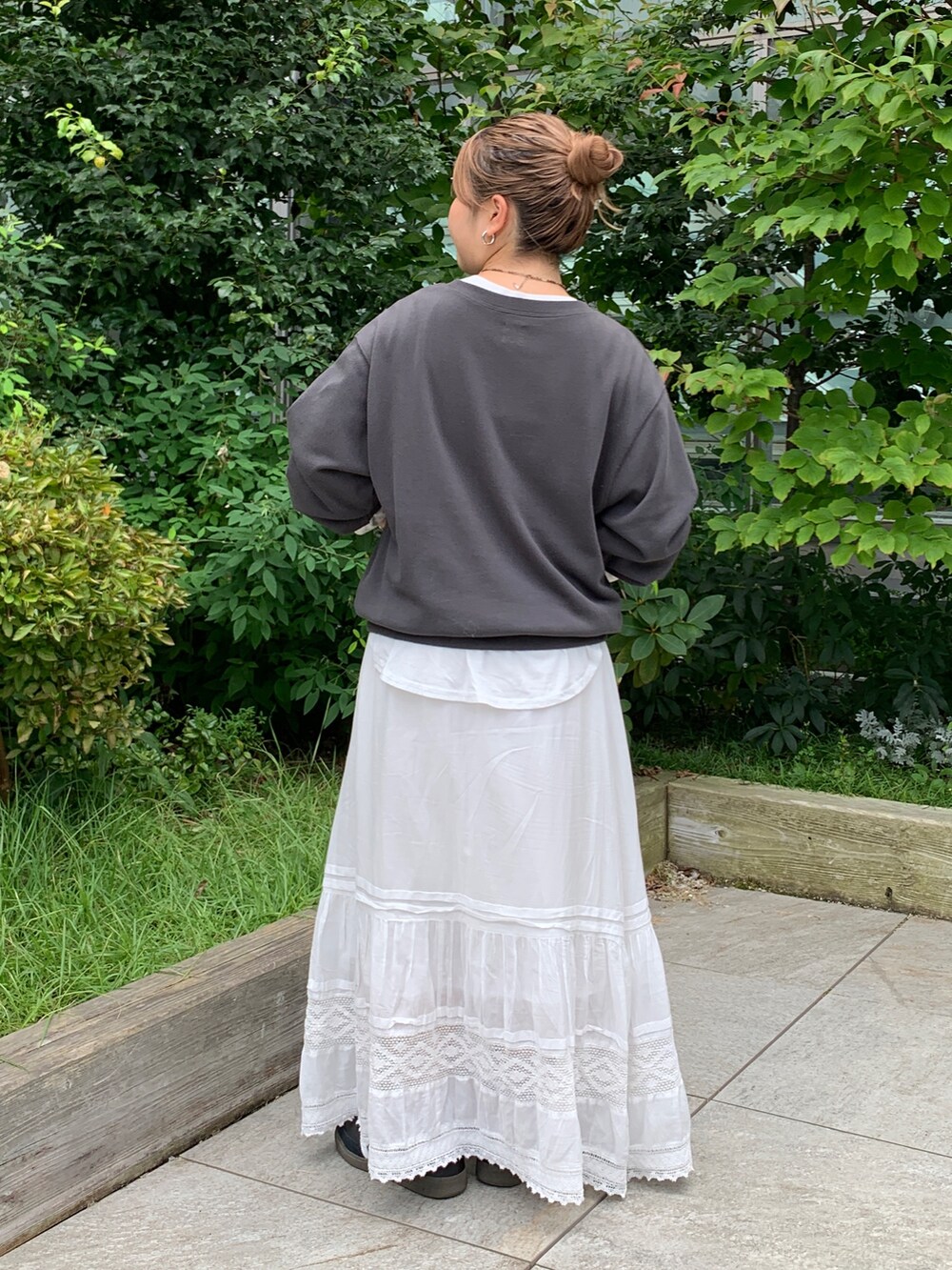 グレー系のスウェット、ホワイト系のTシャツ/カットソー、ホワイト系のスカートを着用したレディースの秋コーディネートの3枚目の写真