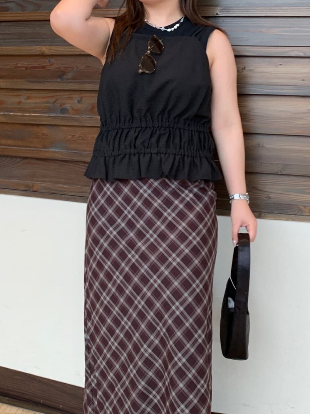 ブラック系のタンクトップ、ブラウン系のスカートを着用したレディースの夏コーディネートの4枚目の写真