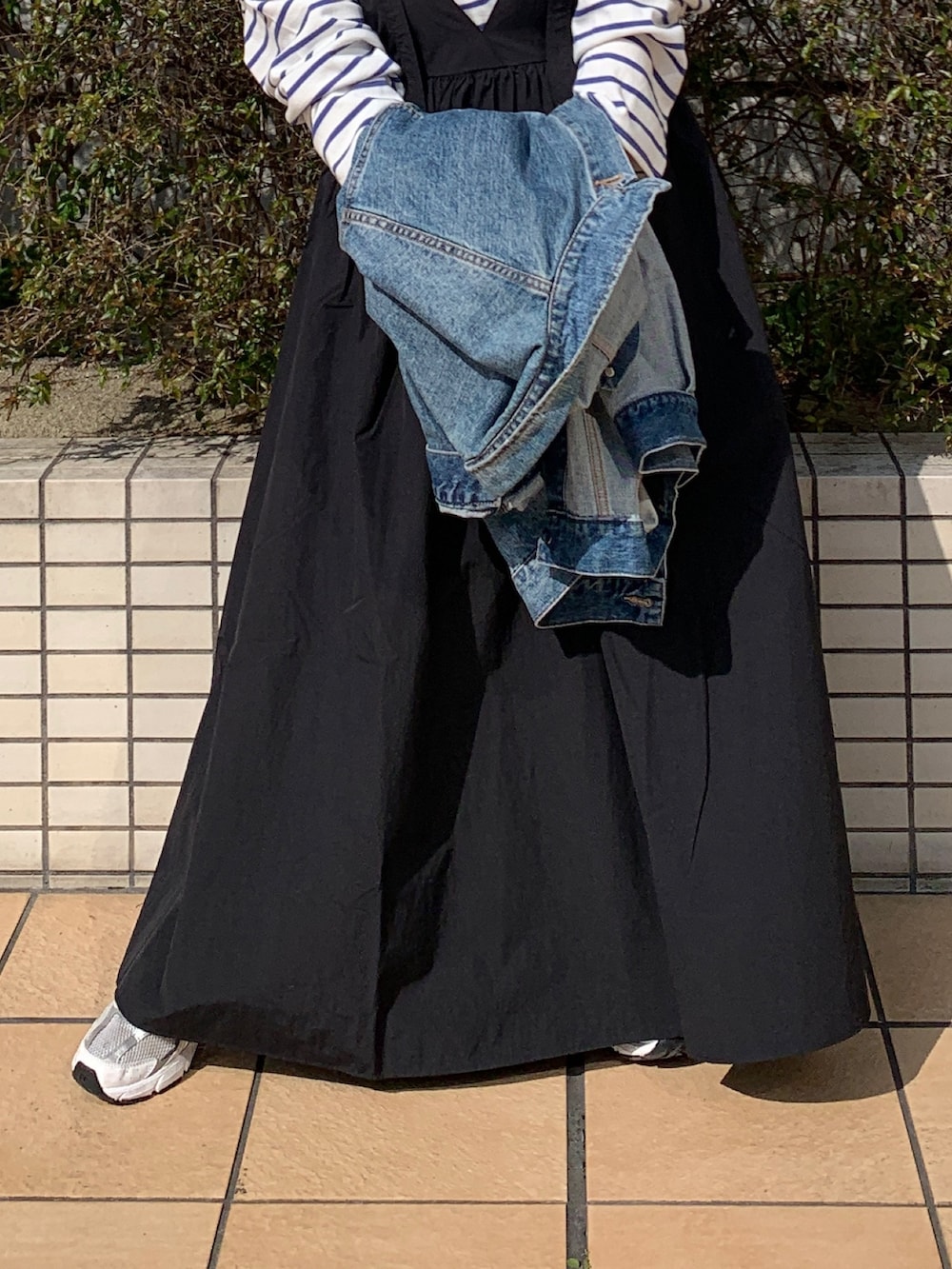 ホワイト系のTシャツ/カットソー、ブルー系のデニムジャケット、ブラック系のワンピースを着用したレディースの春コーディネートの5枚目の写真