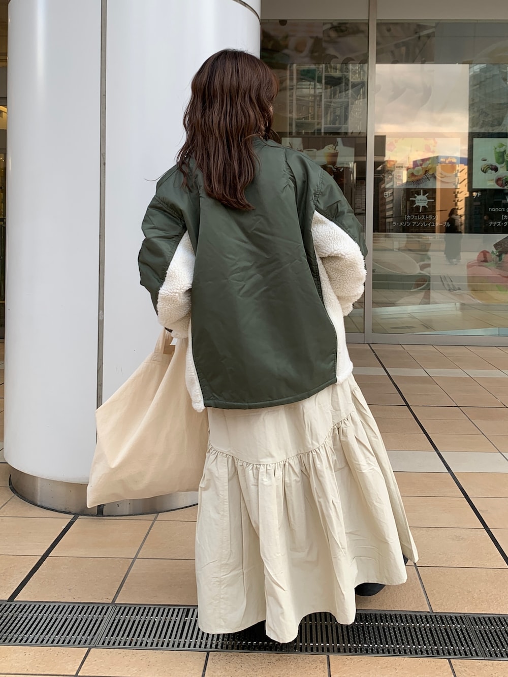 ホワイト系のスカート、ホワイト系のニット/セーター、グリーン系のMA-1を着用したレディースの冬コーディネートの3枚目の写真