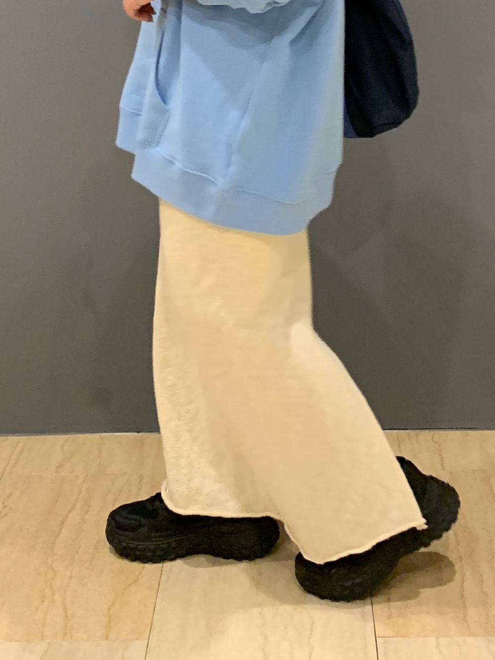 ブルー系のパーカー、ホワイト系のスカート、ブルー系のトートバッグを着用したレディースの冬コーディネートの6枚目の写真