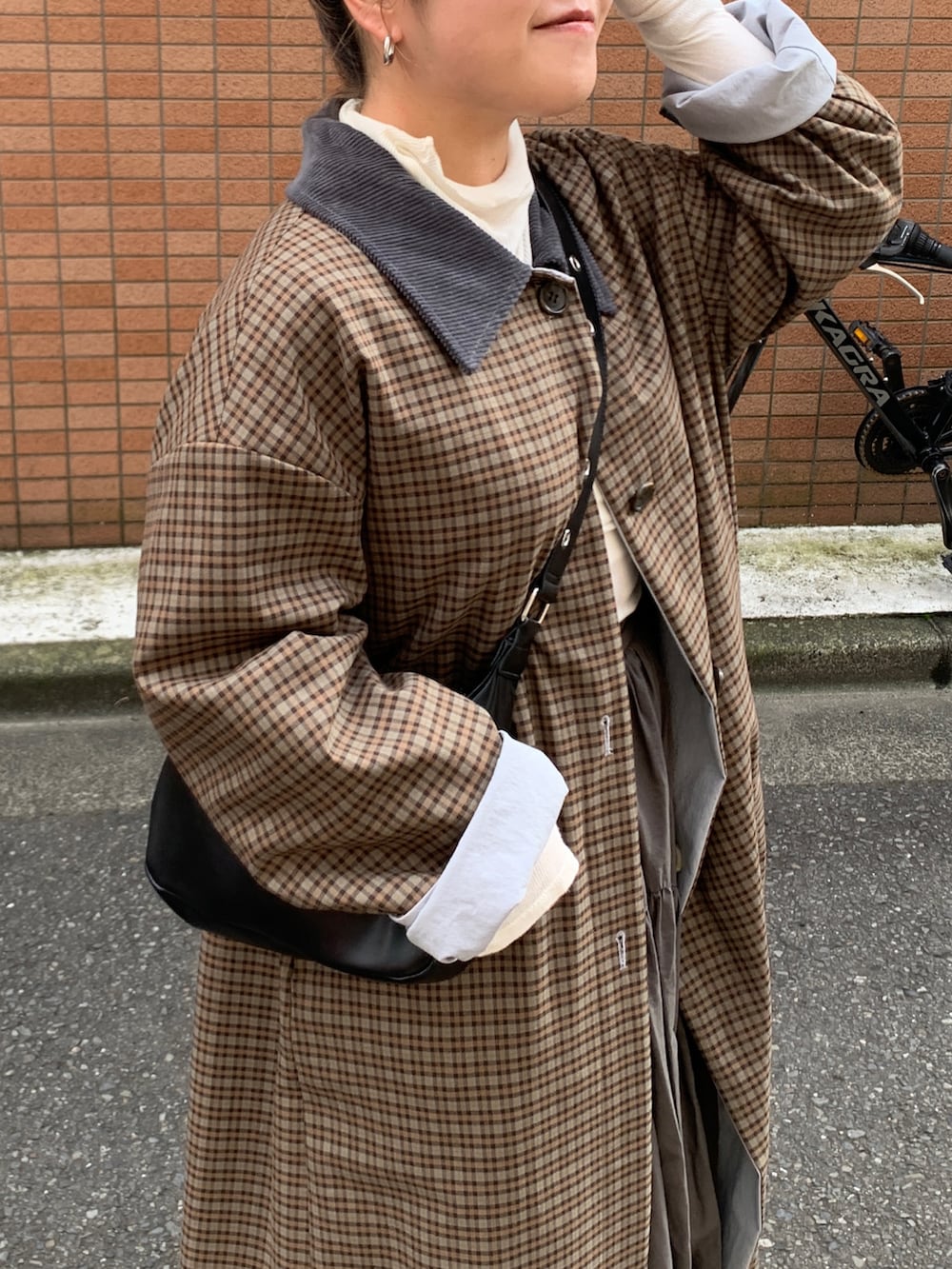 グレー系のスカート、ブルー系のステンカラーコートを着用したレディースの秋コーディネートの4枚目の写真