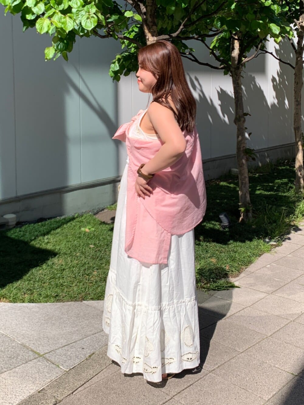 ピンク系のシャツ/ブラウス、ホワイト系のワンピース、ベージュ系のショルダーバッグを着用したレディースの春コーディネートの2枚目の写真