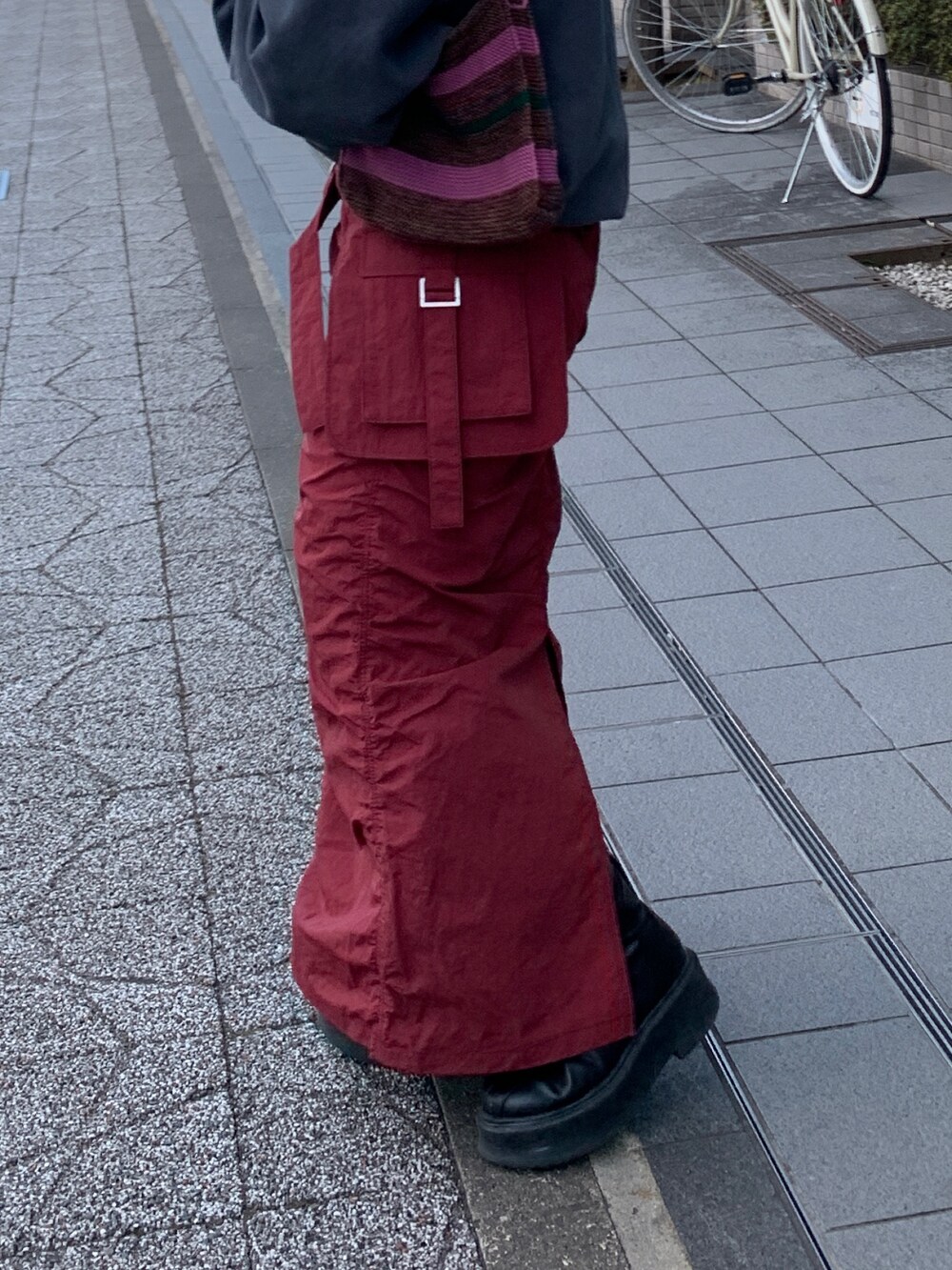 グレー系のスウェット、レッド系のスカート、ブラウン系のハンドバッグを着用したレディースの冬コーディネートの6枚目の写真