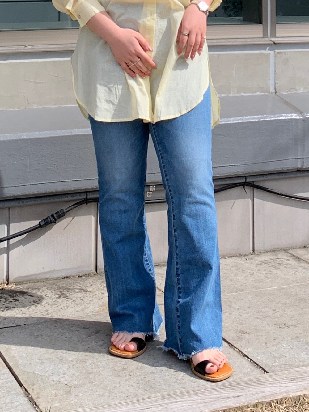 イエロー系のシャツ/ブラウス、ブルー系のデニムパンツ、ブラック系のサンダルを着用したレディースの春コーディネートの4枚目の写真