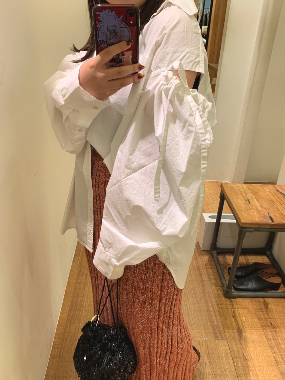 ホワイト系のシャツ/ブラウス、ブラック系のハンドバッグ、レッド系のスカートを着用したレディースの秋コーディネートの5枚目の写真