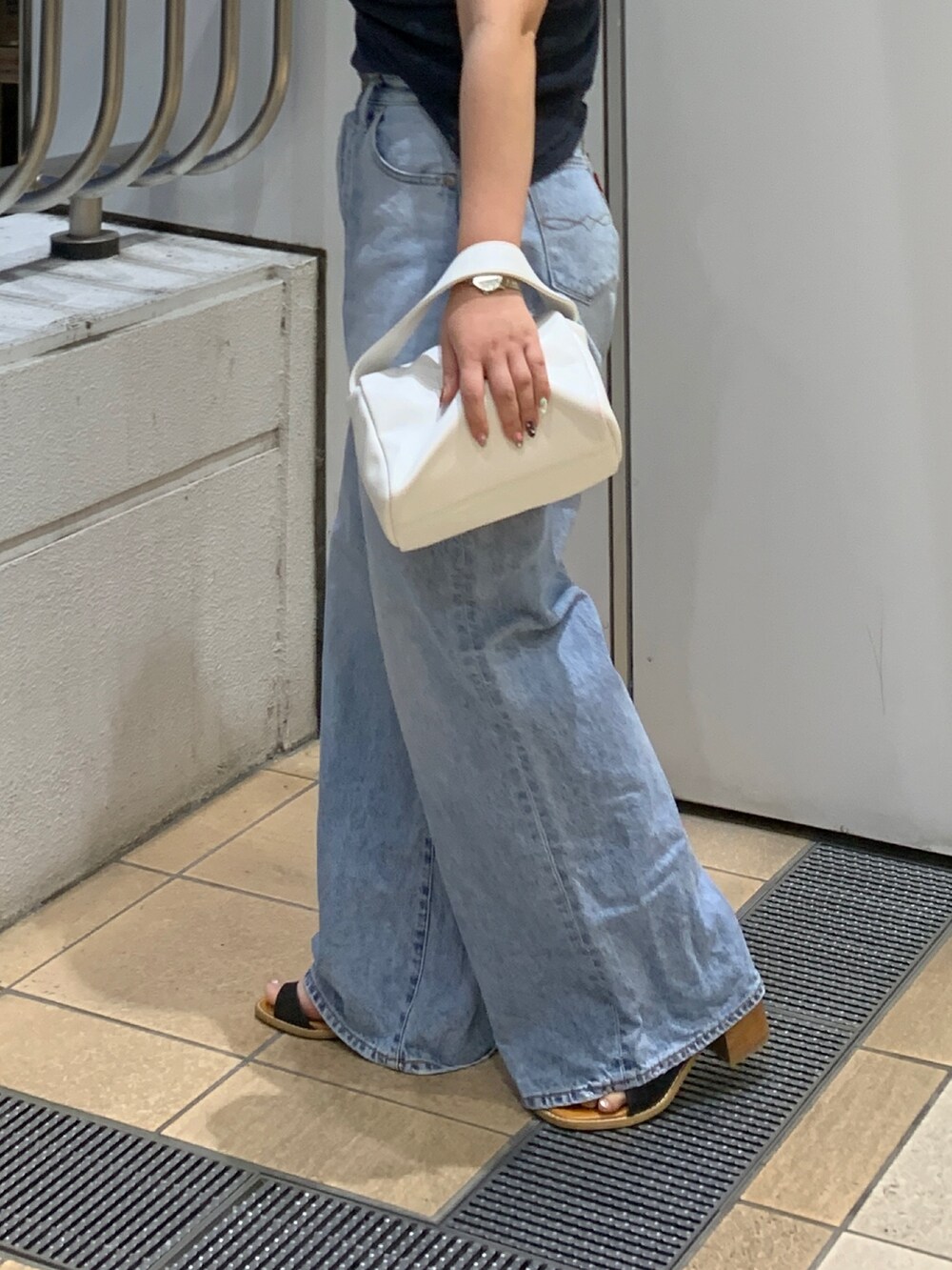 ブルー系のタンクトップ、グレー系のTシャツ/カットソー、ブルー系のデニムパンツを着用したレディースの夏コーディネートの6枚目の写真