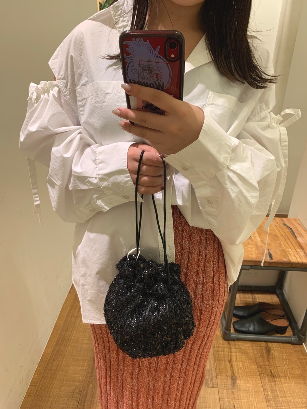 ホワイト系のシャツ/ブラウス、ブラック系のハンドバッグ、レッド系のスカートを着用したレディースの秋コーディネートの4枚目の写真