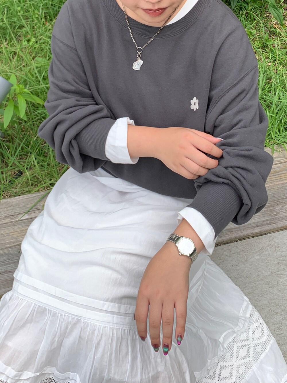 グレー系のスウェット、ホワイト系のTシャツ/カットソー、ホワイト系のスカートを着用したレディースの秋コーディネートの4枚目の写真