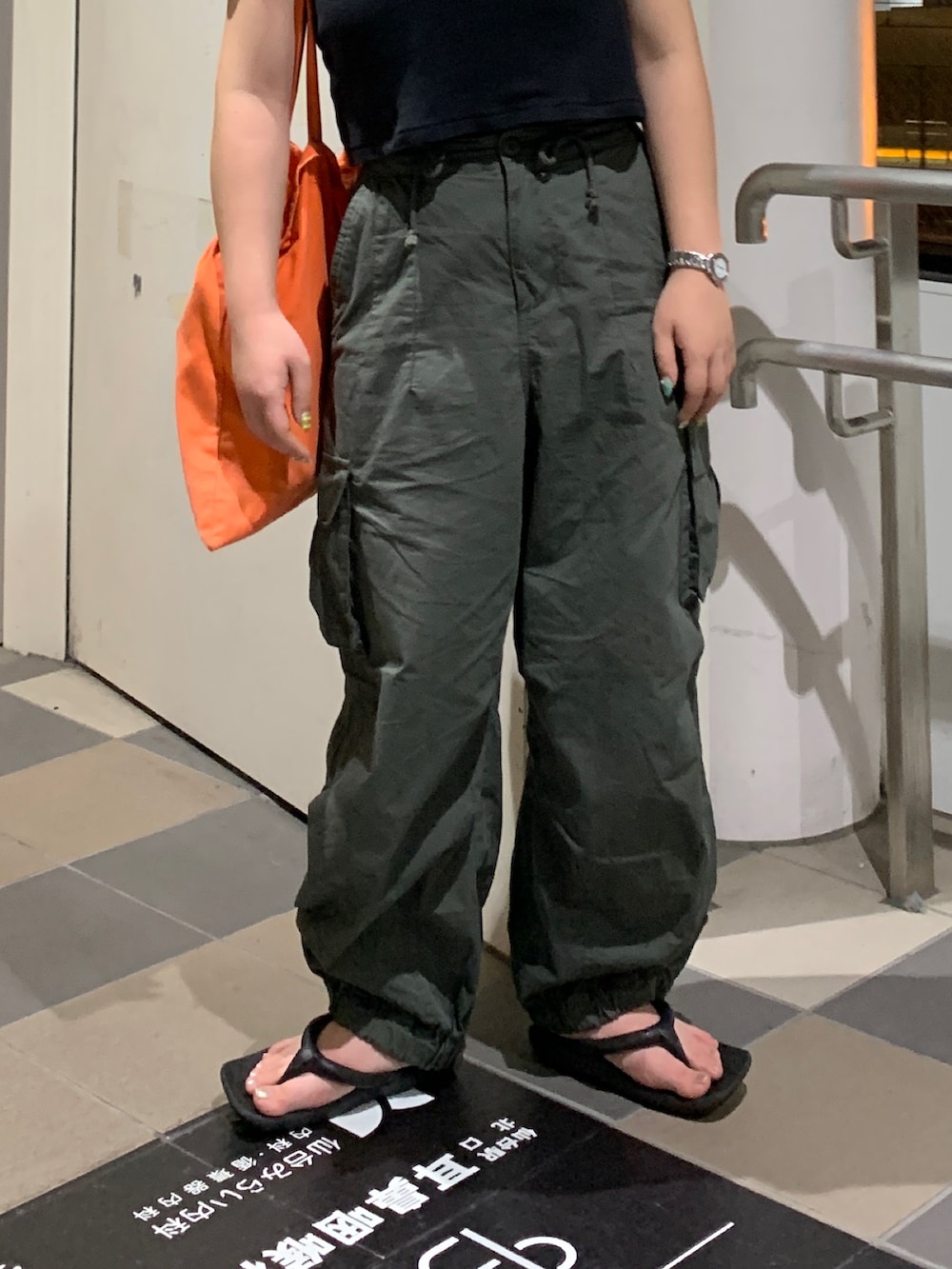 グリーン系のカーゴパンツ、ブラック系のTシャツ/カットソーを着用したレディースの夏コーディネートの5枚目の写真